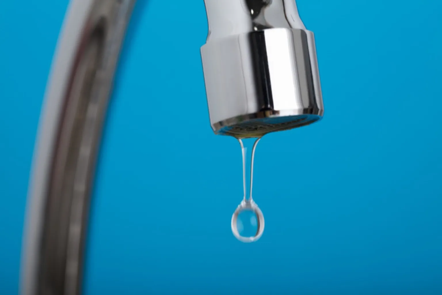 Vanddråbe der drypper fra en blank vandhane
